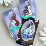 Photograph of 3 different colored snail enamel pins